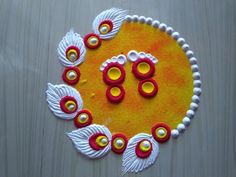 an artistic design made from white and red beads on a yellow surface with two wings