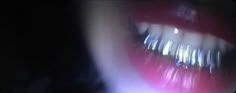 a woman's mouth and teeth are blurry in the dark