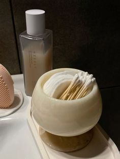 a soap dish with toothbrushes in it next to a bottle of lotion