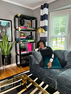 a woman sitting on top of a couch in a living room