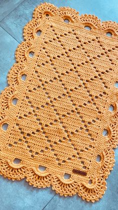 an orange crocheted doily on the ground