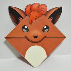 an origami fox with orange hair on it's head is shown in front of a white background