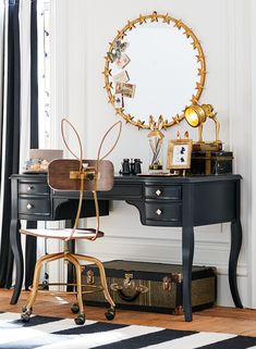 a desk with a mirror, stool and other items on it