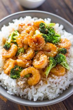 shrimp and broccoli served over white rice in a bowl