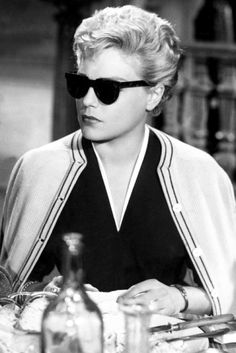 a woman wearing sunglasses sitting at a table