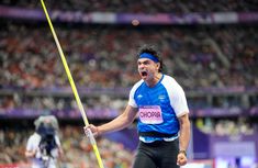 a man holding a pole with his mouth wide open in the middle of a competition