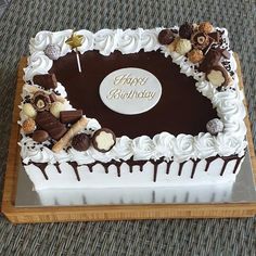 a birthday cake with white frosting and chocolate decorations