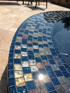 an outdoor table and chairs with blue glass mosaic tiles