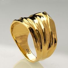 a gold ring is shown on a white surface