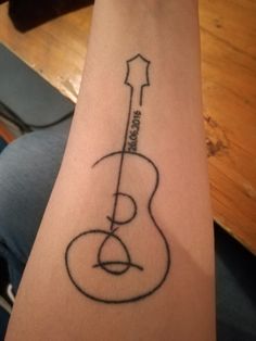 a tattoo on the arm of a person with a guitar