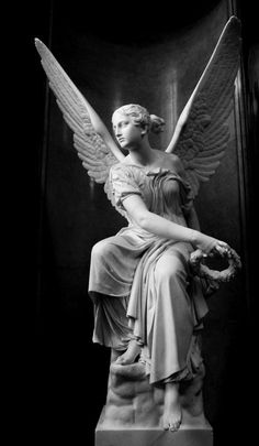 a statue of an angel sitting on top of a marble pedestal in a dark room