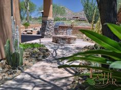 an outdoor patio area with cactus and rocks