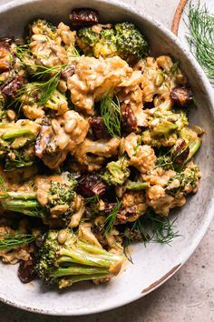 a white bowl filled with broccoli and nuts