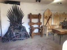 a room filled with lots of wooden chairs and furniture next to a giant iron throne