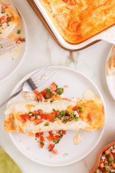 an omelet is on a plate next to other dishes and utensils