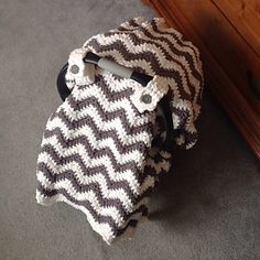 a brown and white blanket sitting on top of a wooden dresser