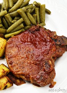 a white plate topped with meat, potatoes and green beans