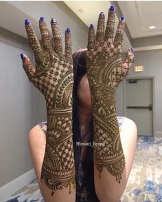 a woman with her hands covered in henna