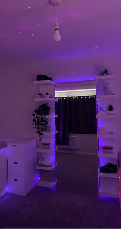 the room is lit up with purple lights and shelving units in front of it