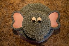 an elephant cake with eyes and ears on it