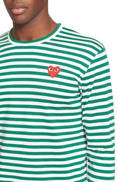 A signature heart appliqué brands the chest of this long-sleeve cotton T-shirt patterned in crisp, classic stripes. 27" length (size Medium) 100% cotton Hand wash, line dry or dry clean Made in Japan Men's Designer Asian Owned Green Cotton Tops With Signature Stripes, White Long Sleeve Tops With Heart Graphic, White Long Sleeve Top With Heart Graphic, White Long Sleeve T-shirt With Contrast Stripes, White Long Sleeve T-shirt With Heart Graphic, Spring Long Sleeve Tops With Signature Stripes, Play Comme Des Garcons, Stripe Long Sleeve, Comme Des Garcons Play