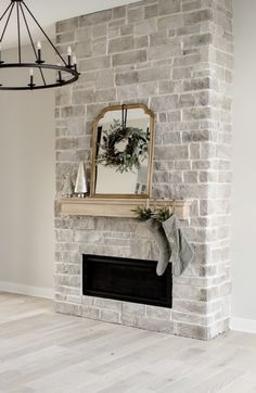 a fireplace with a mirror and stockings hanging on it's mantle, next to a christmas wreath