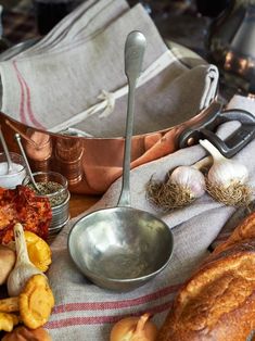 a table topped with bread, garlic and other food items