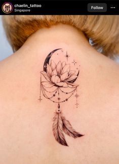 a woman's back neck with a tattoo on it that has a flower and a feather