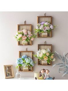 four frames with flowers hanging on the wall next to a vase and other decor items