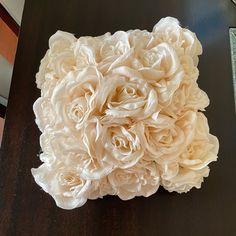 a bouquet of white flowers sitting on top of a wooden table