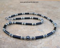 "Men's 4mm and 6mm Beaded Necklace - Black Onyx and Hematite This is a classy and polished necklace of black onyx and gray hematite with stainless steel metal beads. The length of the necklace is mostly made up of black onyx tube beads with five focal beads of larger and smaller round hematite stones. In between the larger and smaller hematite beads are stainless steel saucer shaped spacers beads. Smaller round black onyx beads and disc shaped stainless steel spacer beads are heavily accented be Mens Beaded Necklaces, Boho Men, Necklace Mens, Focal Beads, Hippie Necklace, Palm Beach Gardens, Beach Gardens, Mens Beaded Bracelets, Hematite Beads