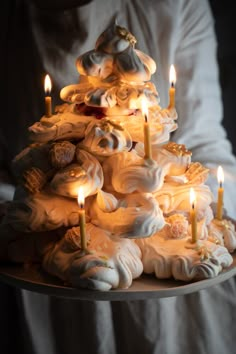 a christmas tree made out of cupcakes with lit candles in the middle on a tray