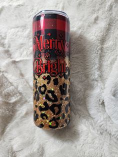 a red and black can with leopard print on it sitting on a white fur covered surface