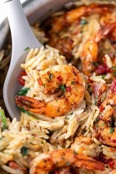 shrimp and pasta in a skillet with a serving spoon