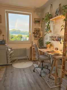 a room with a desk, chair and window overlooking the mountains outside it is furnished with wood flooring