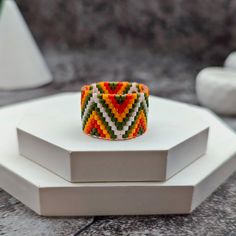 Embrace the vibrant spirit with our handmade Delica beaded wide ring, featuring a striking zigzag pattern in bright hues of yellow, orange, and avocado. Meticulously crafted, this ring showcases an intricate design with hints of African style. This wide band ring is not just an accessory; it's a bold statement piece that reflects your unique style  Our beaded rings are more than just jewelry; they are expressions of individuality and celebrations of bohemian artistry. Whether you're dressing up Handmade Multicolor Bohemian Rings, Handmade Bohemian Multicolor Rings, Bohemian Multicolor Rings For Festival, White Bohemian Beaded Rings, Handmade Bohemian Orange Ring, Style Africain, Tropical Colors, Writing Gifts, Style Boho