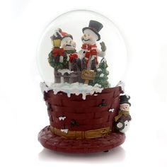 a snow globe with two figurines in it on top of a red basket