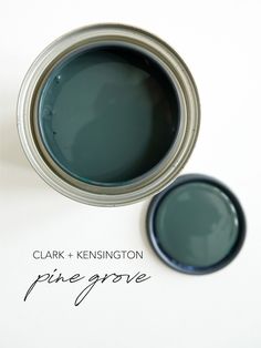 two cans of paint sitting next to each other on a white surface with the words clark and kennington pine grove