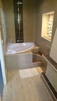 a bathroom with tiled walls and flooring next to a bathtub in the corner