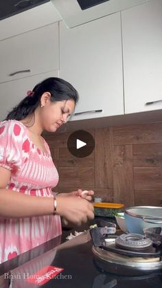 a woman standing in front of a stove preparing food on top of a burner