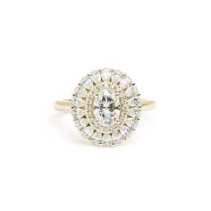 a yellow gold ring with an oval cut diamond surrounded by smaller round diamonds on the band