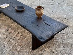 a wooden table with a vase on it and a book sitting on top of it