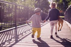 two children walking on a bridge holding hands with the words having kids changes everything in front of them