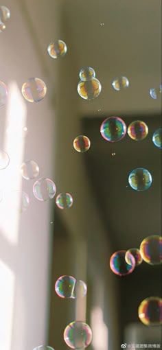 soap bubbles floating in the air near a window