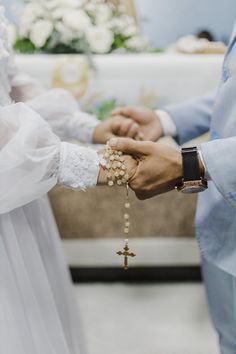 a man and woman holding hands in front of a cross