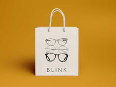 a white shopping bag with glasses on it against a yellow background that says blnk