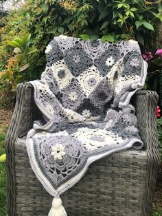 a wicker chair with a crocheted blanket on it