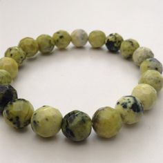 This is a stretch bracelet made with 10mm faceted Connemara marble beads in mainly lime green tones. As it is stretch it fits most wrist sizes.  Sold in an organza bag with designer tags. Look at my shop for more Connemara marble jewelry. Connemara marble is a beautiful and unusual marble rich in forsterite olivine and serpentine which gives it its green colour. Found in the West of Ireland it is Ireland's most famous stone. It's green colour symbolises Ireland.   Look closely and you will see s Casual Green Stretch Bracelet With Natural Stones, Green Faceted Beads Stretch Bracelet Gift, Green Faceted Beads Stretch Bracelet For Gift, Green Stretch Bracelet With Faceted Beads As Gift, Green Stretch Bracelet With Faceted Beads For Gift, Marble Bracelet, Irish Rock, Faceted Bead Bracelet, Connemara Marble