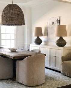 a dining room table with chairs and lamps