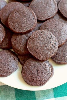 chocolate cookies on a white plate with green table cloth